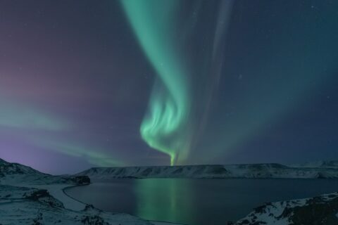 Photo of Northern lights shining on water